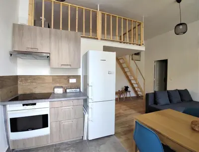 a kitchen with a white refrigerator and a table at 2 à 6 personnes - WELCOME TO NICE ! LOGEMENT PORT in Nice