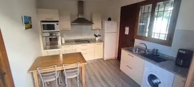 a kitchen with a table and a sink and a refrigerator at LA CASA in Cagnes-sur-Mer