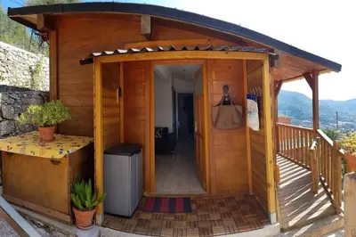 a wooden cabin with a wooden door and a balcony at Le Chalet de la Pierreraie Côte d'Azur Piscine Terrasse et Vue Mer in Drap