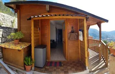 a wooden cabin with a door open on a deck at Le Chalet de la Pierreraie Côte d'Azur Piscine Terrasse et Vue Mer in Drap