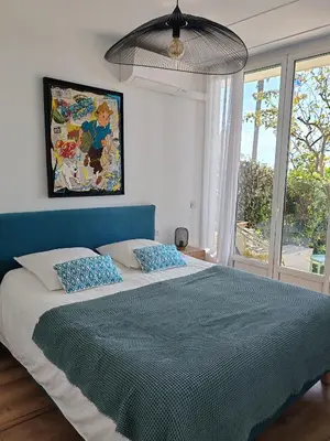 a living room with a yellow couch and a kitchen at Garden Atlantide Promenade in Nice