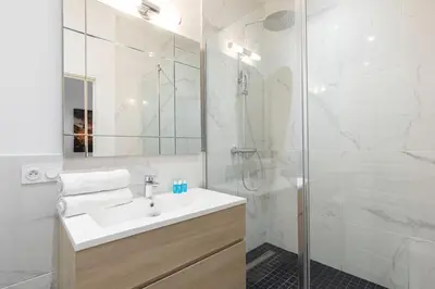 a white bathroom with a sink and a shower at Promenade, 2pièces chic et clim avec terrasse Location éligible au Bail Mobilité Mobility Lease in Nice