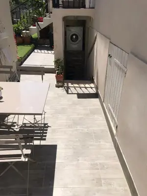 a patio with a table and a washing machine at Jolie appartement Nice proche mer et aéroport Une chambre plus salon avec cuisine in Nice