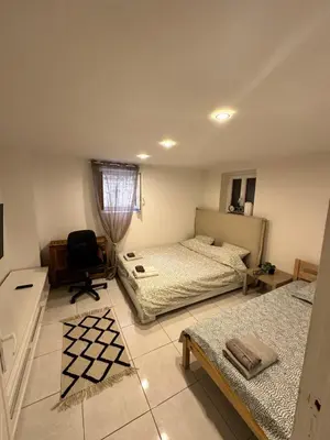 a bedroom with two beds and a chair in it at Jolie appartement Nice proche mer et aéroport Une chambre plus salon avec cuisine in Nice