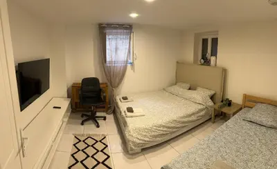 a bedroom with a bed and a chair and a television at Jolie appartement Nice proche mer et aéroport Une chambre plus salon avec cuisine in Nice