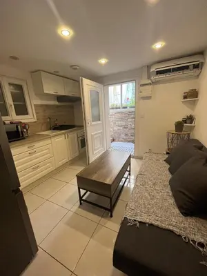 a kitchen and living room with a couch and a table at Jolie appartement Nice proche mer et aéroport Une chambre plus salon avec cuisine in Nice