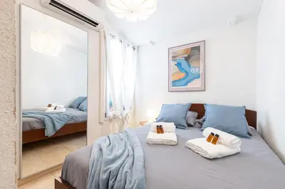 a bedroom with a blue bed and a mirror at FEEL HOME - BARILLERIE in Nice