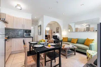 a kitchen and living room with a table and a couch at FEEL HOME - BARILLERIE in Nice