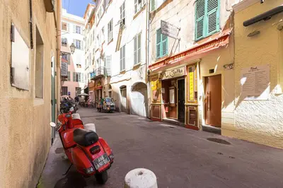 a red scooter parked on the side of a street at FEEL HOME - BARILLERIE in Nice