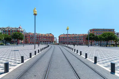 a street with train tracks in front of buildings at FEEL HOME - BARILLERIE in Nice