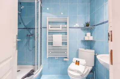 a blue tiled bathroom with a toilet and a shower at FEEL HOME - BARILLERIE in Nice