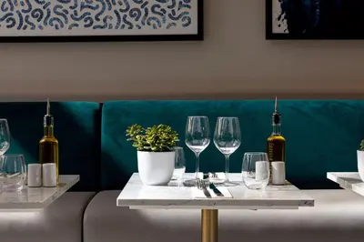 a table with wine glasses and a potted plant on it at Sheraton Nice in Nice