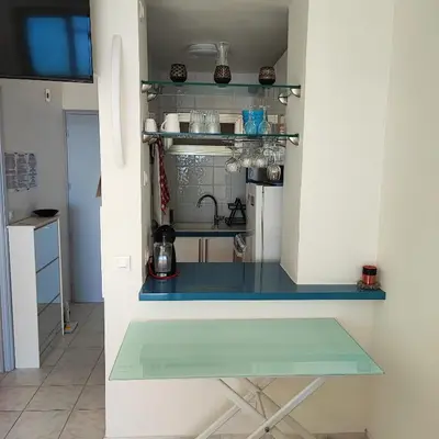 a kitchen with a glass counter in a room at Grand studio bord de mer- accès direct aux plages in Saint-Laurent-du-Var