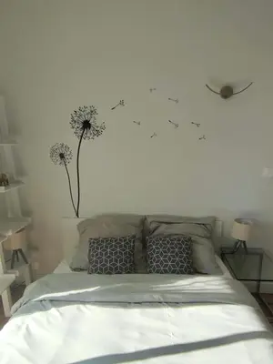 a bedroom with a bed with dandelions on the wall at Un brin de paille in Cagnes-sur-Mer