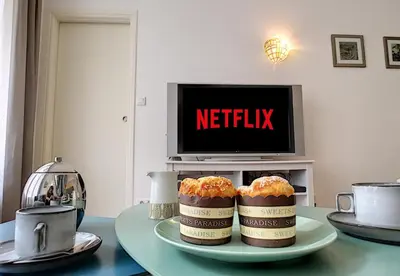 two muffins on a plate on a table with a tv at Nestor&Jeeves - MARIA BEACH - Central - By sea in Nice