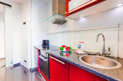 a kitchen with red cabinets and a sink at LE TIVOLI AP4264 By Riviera Holiday Homes in Nice