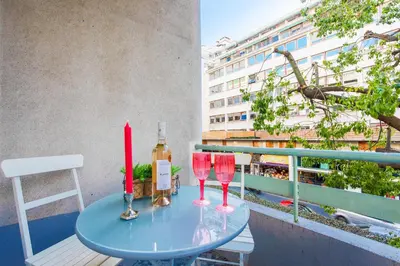 a table with two wine glasses on a balcony at LE TIVOLI AP4264 By Riviera Holiday Homes in Nice