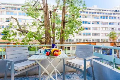 a table with fruit on a balcony with two chairs at LE TIVOLI AP4264 By Riviera Holiday Homes in Nice