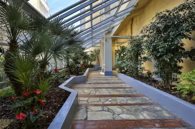 a walkway in a greenhouse with plants and flowers at Balcon vue Coulée Verte. Luxe Plein cœur de Nice in Nice