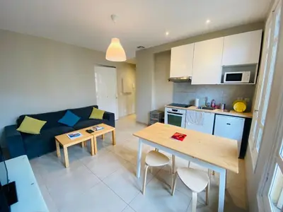 a kitchen and living room with a table and a couch at Le Delfino PORT DE NICE in Nice