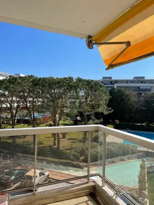 a balcony with a view of a car and a pool at appartement bord de mer avec piscine in Cagnes-sur-Mer