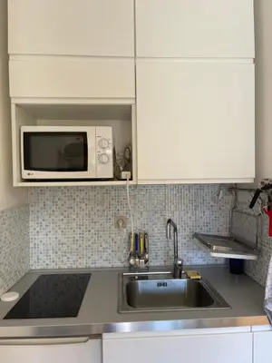 a kitchen with a sink and a microwave at appartement bord de mer avec piscine in Cagnes-sur-Mer