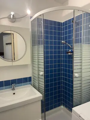 a bathroom with a sink and a shower with blue tiles at appartement bord de mer avec piscine in Cagnes-sur-Mer