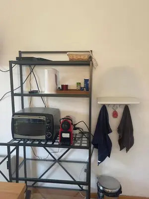 a shelf with a microwave and a radio in a room at appartement bord de mer avec piscine in Cagnes-sur-Mer