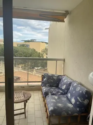 a living room with a couch and a balcony at appartement bord de mer avec piscine in Cagnes-sur-Mer