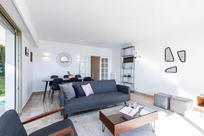 a living room with a couch and a table at Villefranche Sur Mer:Appartement-villa, Vue mer, jardin, parking. in Villefranche-sur-Mer