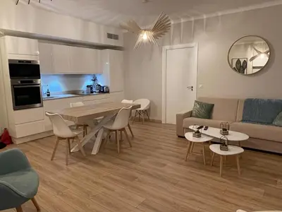 a living room with a couch and a table and chairs at Reine Marie :Top floor Carré d'or avec accès direct à la mer in Nice