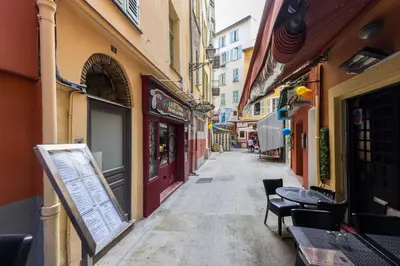 an empty alley with tables and chairs on a city street at Charming 2 Bdr Old Town in Nice