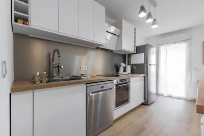a kitchen with white cabinets and stainless steel appliances at Large 2 Bdr at Nice Port in Nice