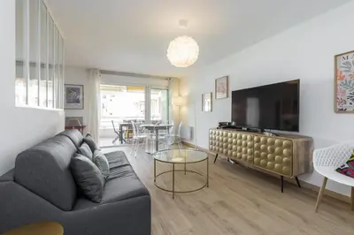 a living room with a couch and a flat screen tv at Large 2 Bdr at Nice Port in Nice
