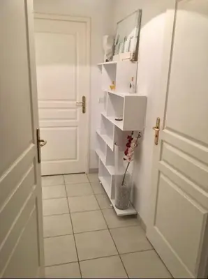 a hallway with a white door and a white tile floor at L Arieta - Appartement 3 pièces vue mer, parking & piscine in Nice