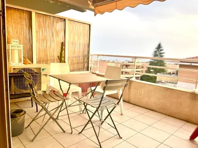a table and chairs on a balcony with a view at L Arieta - Appartement 3 pièces vue mer, parking & piscine in Nice