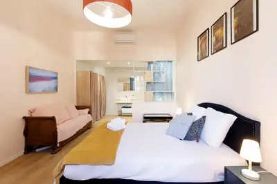 a bedroom with a large bed and a couch at Maison Bianchi - Old Town Flower market in Nice