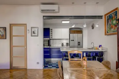 a kitchen with a wooden table and blue cabinets at Maison Bianchi - Old Town Flower market in Nice