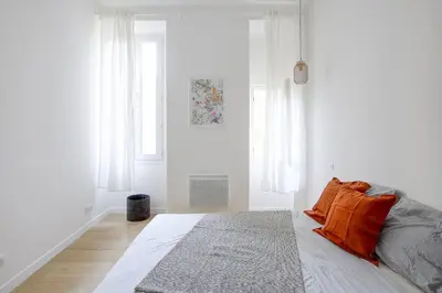 a bedroom with a bed and a door to a balcony at Appart Hotel Jaures - Boutique apartments in Nice