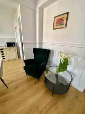 a living room with a black chair and a glass table at Le Nid Blanc Nice Centre in Nice