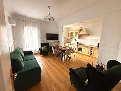 a living room with a green couch and a table at Le Nid Blanc Nice Centre in Nice