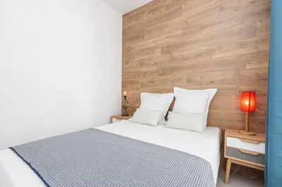 a bedroom with a bed and a wooden wall at MY CASA - PROM 163 - 2 rooms with terrace Promenade des Anglais in Nice