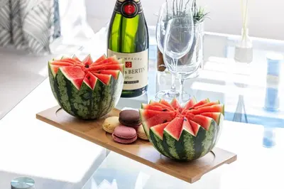 a table with two watermelons and a bottle of wine at MY CASA - PROM 163 - 2 rooms with terrace Promenade des Anglais in Nice