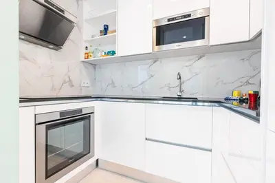 a white kitchen with marble counter tops and appliances at MY CASA - PROM 163 - 2 rooms with terrace Promenade des Anglais in Nice