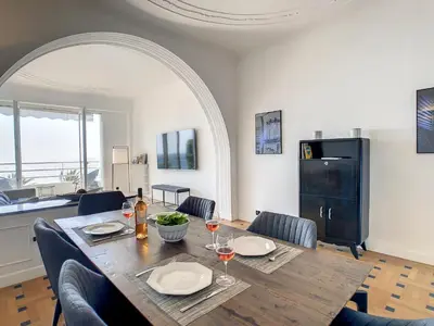 a dining room with a table and chairs with wine glasses at Nestor&Jeeves - BLUE PROMENADE - Sea front - Central - Luxe in Nice