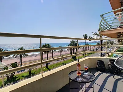 a balcony with a table and two glasses of wine at Nestor&Jeeves - BLUE PROMENADE - Sea front - Central - Luxe in Nice