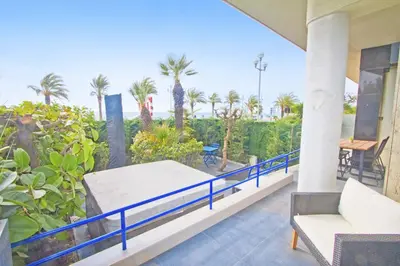a balcony of a house with a bed and palm trees at Luxury Garden Jacuzzi Promenade in Nice