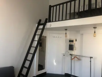 a ladder leading up to a loft bed at Charmant studio proche mer in Nice