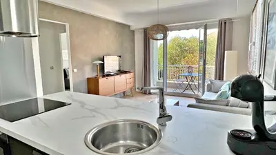 a kitchen with a sink and a living room at LA LANTERNE in Nice