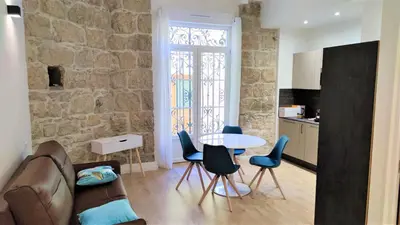 a living room with a couch and a table and chairs at hypercentre lamartine 001 in Nice